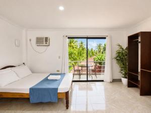 a white bedroom with a bed and a balcony at Yayay Siargao - Generator & Starlink in General Luna