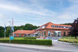 a large brick building on a city street at Severin Kursuscenter og Konferencehotel in Middelfart