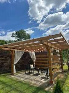 a wooden pergola with a bench on a patio at Balaton Apartamenty in Trzebinia