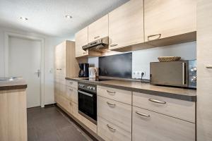 a kitchen with wooden cabinets and a stove top oven at Ankerhaus 1 in Trent