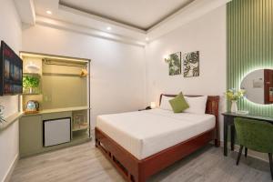 a bedroom with a bed and a table and a desk at Cactusland Hotel Tan Binh Near T3 Station in Ho Chi Minh City +25 photos