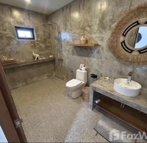 a bathroom with a toilet and a sink and a mirror at Villa jay in Na Mueang