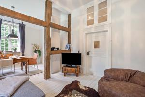 a living room with a couch and a tv at Gutshaus Benckendorf - Wohnung Erde in Dassow
