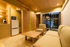 a living room with a couch and a chair and a refrigerator at The Besso Soso Kyoto in Kyoto