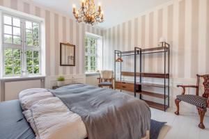 a bedroom with a bed and a chandelier at Gutshaus Benckendorf - Wohnung Erde in Dassow