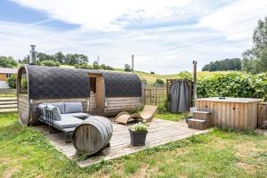 a wooden deck with a couch and chairs on a yard at Belroki Ranch in Waldeck
