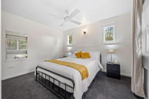 a white bedroom with a large bed and two windows at What-A-View Cottage Halls Gap in Halls Gap
