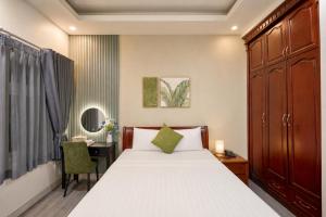 a bedroom with a bed and a desk and a chair at Cactusland Hotel Tan Binh Near T3 Station in Ho Chi Minh City
