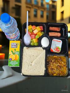 a lunch box with a sandwich and other foods and a bottle of water at Star Emirates Downtown Hotel Salalah in Salalah