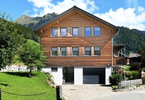 ein großes Holzhaus mit Garage in der Unterkunft Hausblick in Au im Bregenzerwald