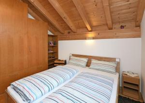 ein großes Bett in einem Zimmer mit Holzdecke in der Unterkunft Hausblick in Au im Bregenzerwald