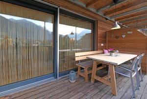 ein hölzerner Terrassentisch und eine Bank auf einer Terrasse in der Unterkunft Hausblick in Au im Bregenzerwald