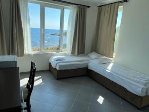 a bedroom with two beds and a view of the ocean at Вила Арапя in Tsarevo