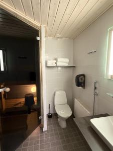 a bathroom with a toilet and a tub and a sink at Hotelli Puustelli Nivala in Nivala