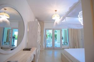 a white bathroom with a mirror and a bed at Villa Zuri at Papa Remo in Watamu +44 photos