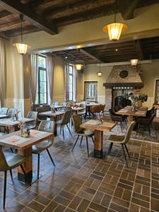 a restaurant with tables and chairs and a fireplace at Orange Parkway Hotel in Diest