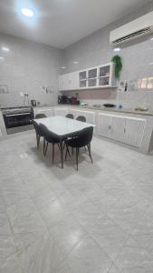 a kitchen with a table and chairs in it at Al Hawli pool gathering in Salalah