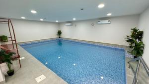 a large blue swimming pool in a room at Al Hawli pool gathering in Salalah +20 photos