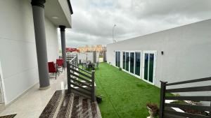 a balcony with green grass on a white building at Al Hawli pool gathering in Salalah