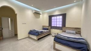 two beds in a room with a window at Al Hawli pool gathering in Salalah