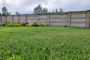 a yard with a fence and some flowers at Cozy stays in Giachumi