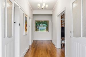 a hallway with white walls and wood floors and a painting at Brighton Belle Stawell in Stawell