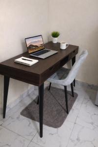 a laptop computer sitting on a wooden desk with a chair at Cozy stays in Giachumi
