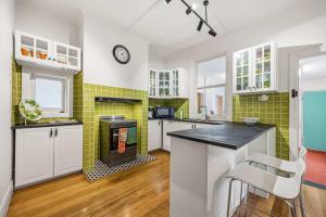 a kitchen with white cabinets and green tiles at Brighton Belle Stawell in Stawell +28 photos