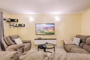 a living room with two couches and a tv on the wall at Cozy stays in Giachumi