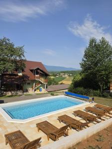 a swimming pool with chaise lounge chairs and a swimming pool at Apartman Silvija in Otočac