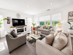 a living room with two couches and a tv at Route 66 Desert Retreat 3 Bedroom Home With Garden in Victorville