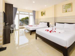 two beds in a hotel room with roses on them at Diamond crown 2 Hotel in Ho Chi Minh City