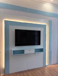 a living room with a flat screen tv on a wall at Golden Lotus Hotel in Buôn Hồ