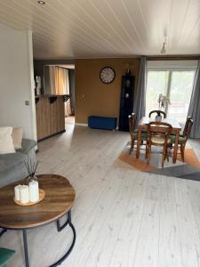 a living room with a table and a dining room at Le Clos Tranquille in Saint-Privé