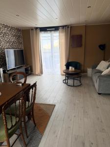 a living room with a couch and a table at Le Clos Tranquille in Saint-Privé