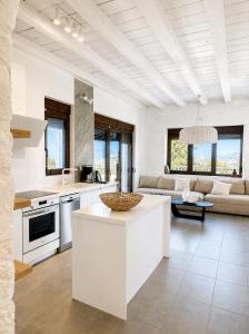 a kitchen and living room with white cabinets at Villa Ikaros in Agia Triada