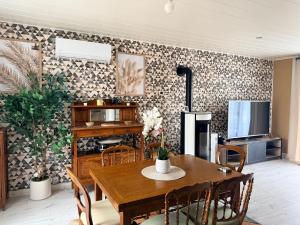 a dining room with a table and a tv at Le Clos Tranquille in Saint-Privé +14 photos