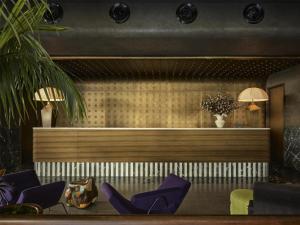 a waiting room with purple chairs and a counter at Hannah St Hotel Melbourne in Melbourne