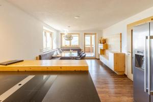 a kitchen and living room with a wooden table at Ferienwohnung La-Wurm mit privatem Whirlpool in Hart im Zillertal