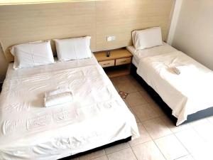 two beds sitting next to each other in a room at Hotel O Hilltowne in Kampong Kawak