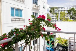 a plant on a balcony with pink flowers at QUANG SAIGON Hotel- 40-7 Bùi Viện-Walking street in Ho Chi Minh City