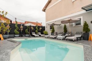 a swimming pool with chairs and umbrellas next to a building at Apartments Vidanovic in Ohrid