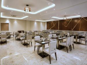 a dining room with tables and chairs and a chalkboard at Red Tullip Md Valley Resort & Spa - Luxury Resort With Swimming Pool, Udaipur in Udaipur