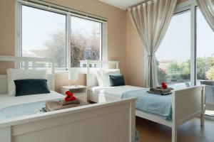 a bedroom with two beds and a large window at 3BR Panoramic Sea View Villa with Private Pool by Cyprus Horizons in Pissouri