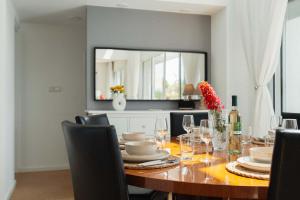 a dining room with a table with chairs and a mirror at 3BR Panoramic Sea View Villa with Private Pool by Cyprus Horizons in Pissouri
