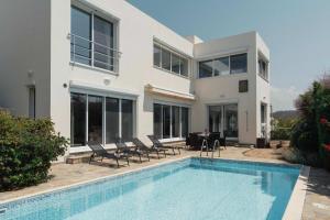 a house with a swimming pool in front of it at 3BR Panoramic Sea View Villa with Private Pool by Cyprus Horizons in Pissouri