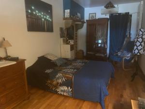 a bedroom with a bed and a wooden floor at La maison bleue de Béa in Musigny