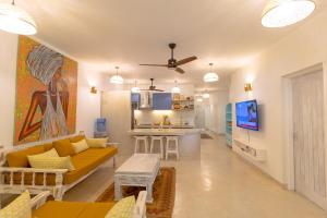 a living room with a couch and a kitchen at Villa Zuri at Papa Remo in Watamu