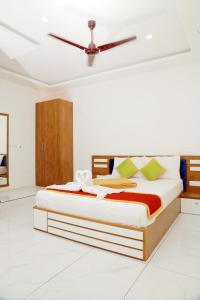 a bed in a white room with a ceiling at RKM Pearl in Cochin