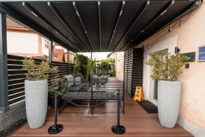 a patio with a table and two large vases at Apartments Vidanovic in Ohrid